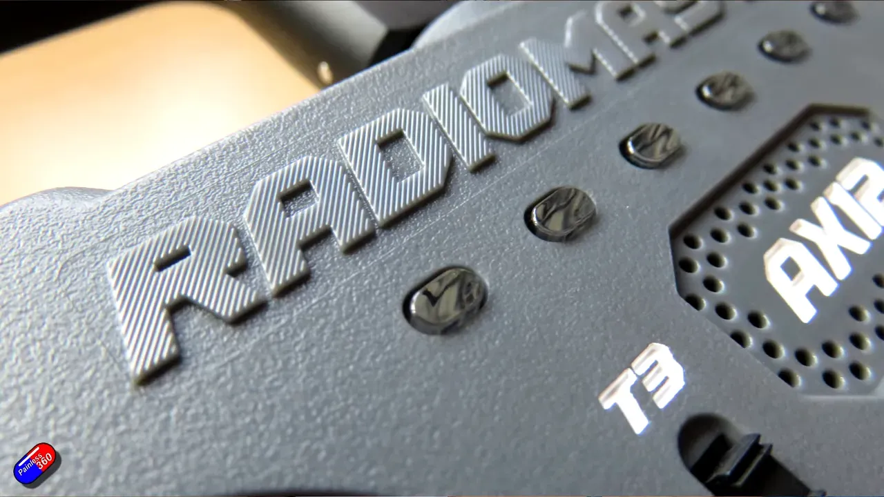 Close-up of RadioMaster AX12 embossed logo, speaker vent and T3 label on textured plastic surface.