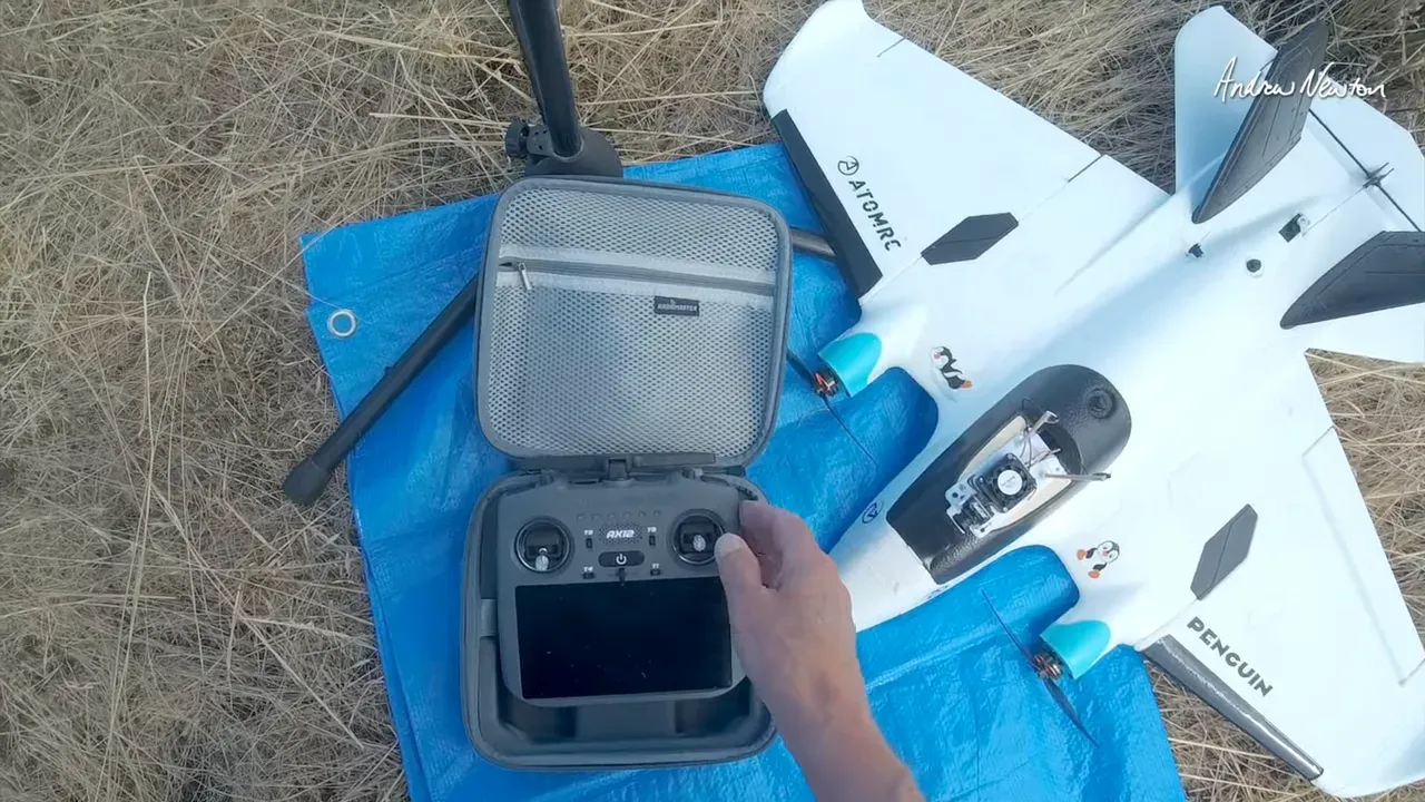 Radiomaster AX12 transmitter open with hand on the front switches and touchscreen section outdoors