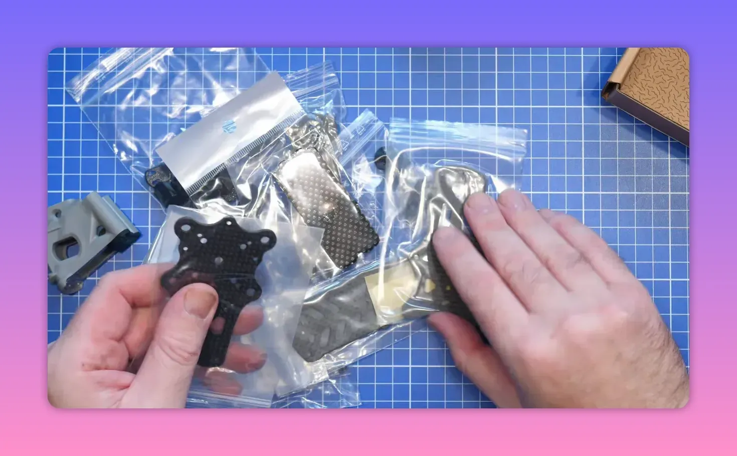 ERA Mini kit parts and carbon frame components laid out in packaging on a blue cutting mat