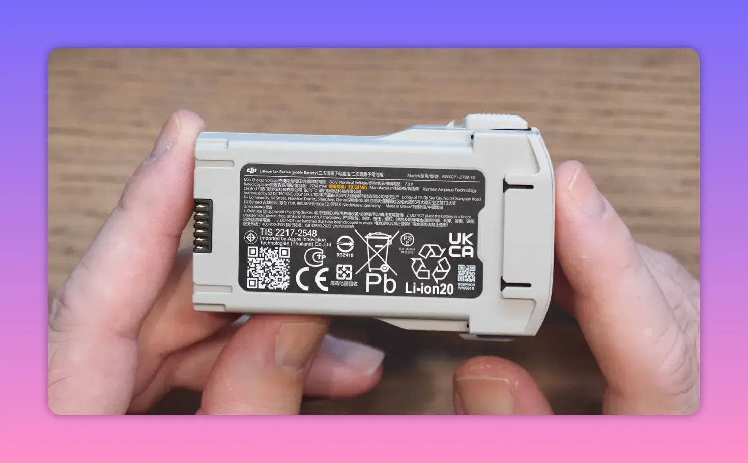 Close-up of the DJI Lito X1 battery pack label held by hands over a wooden table