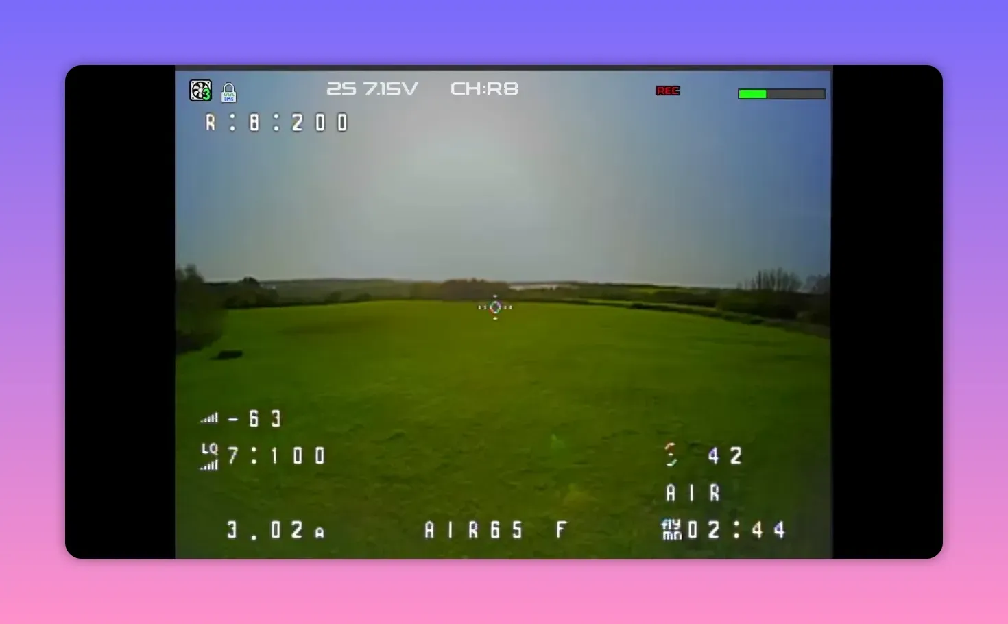 Analogue FPV HUD view from the BetaFPV Air65 II on CH R8 over open grass showing REC status and HUD telemetry