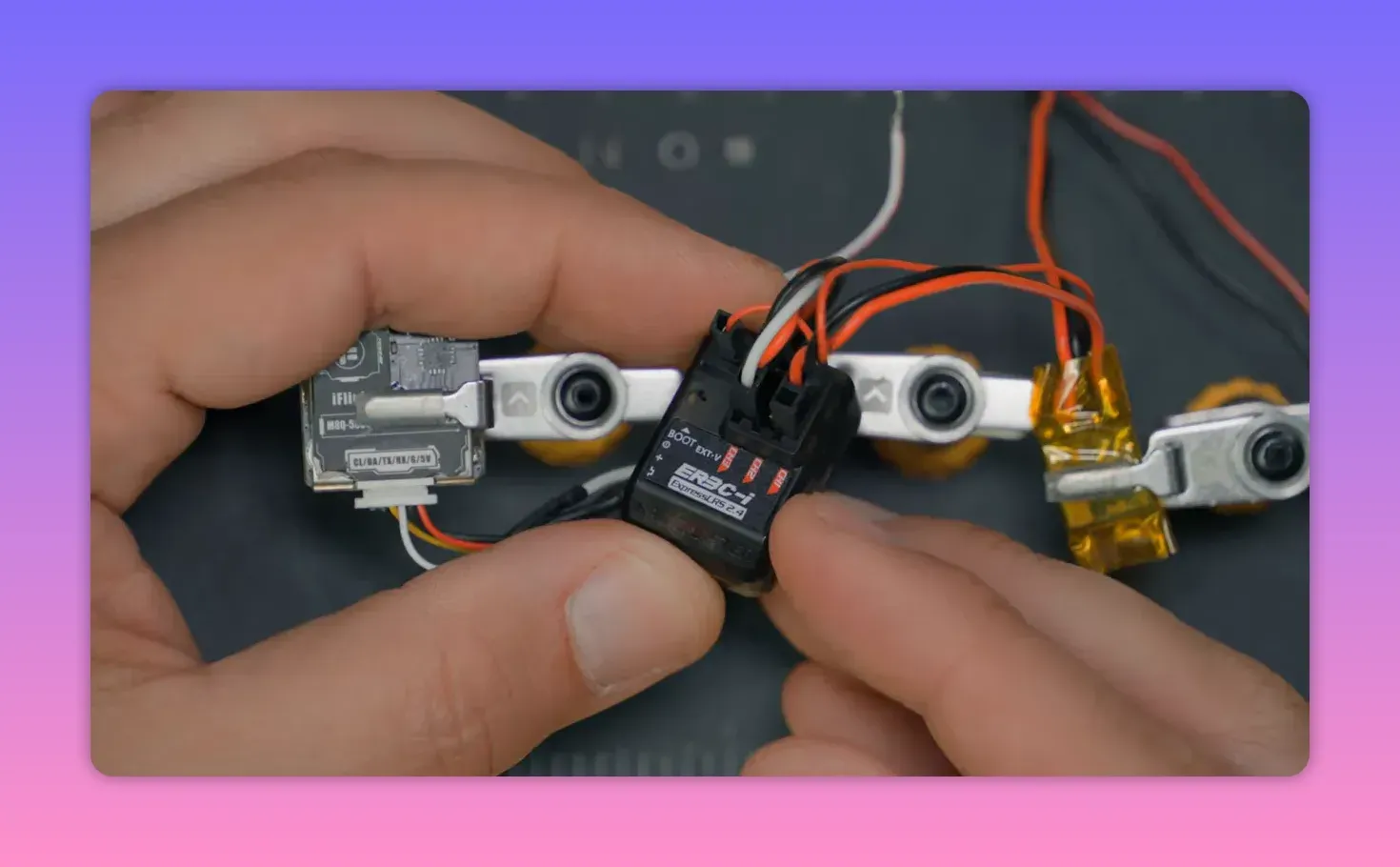 Close-up of an ExpressLRS receiver board being held, showing the ER4 receiver markings