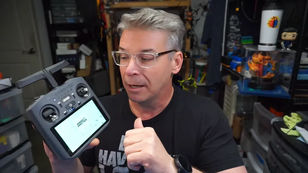 Nick Burns holding the RadioMaster AX12 transmitter with the Android home screen visible