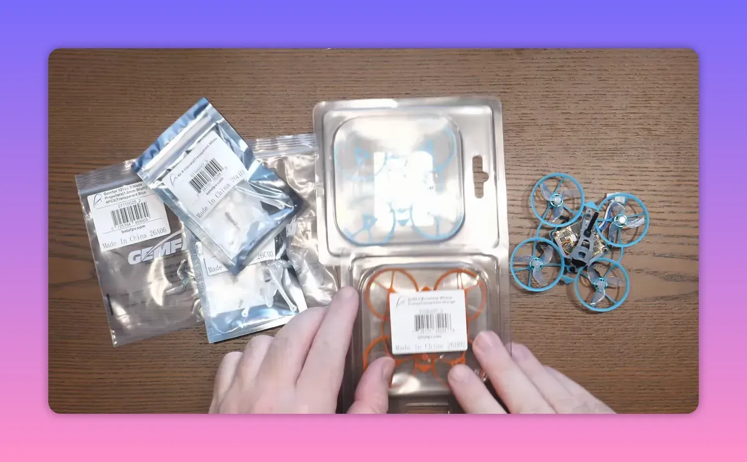 Air65 II freestyle replacement spares in packaging laid out next to the whoop on a wooden table