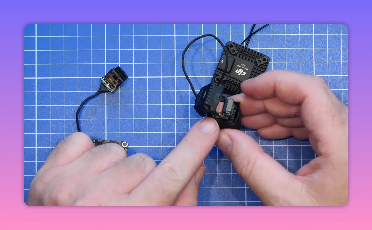 Wiring and DJI O4 Pro camera PCB assembly with integrated gyro module on a grid workbench