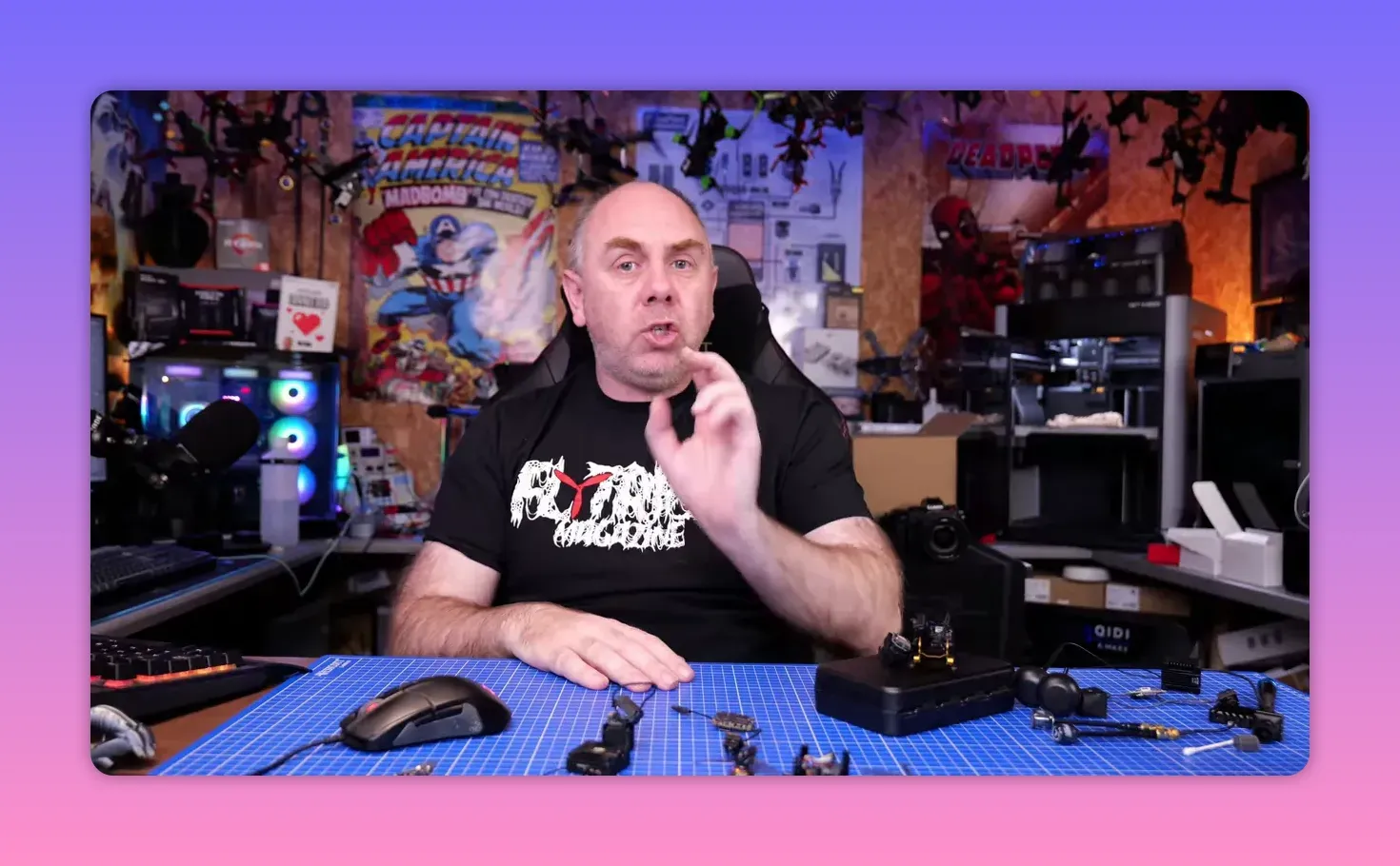 Presenter gesturing while explaining unknown causes of the DJI O4 Pro 2026 gyro issue, with FPV drones and equipment in the background