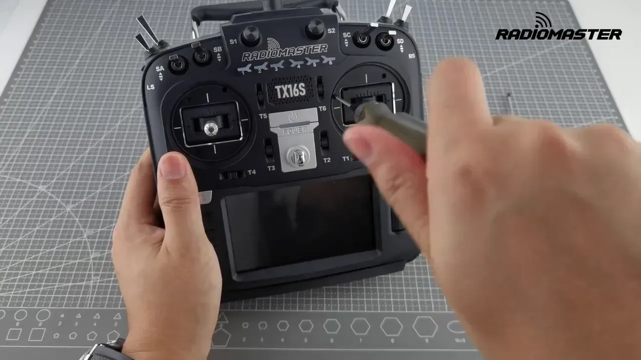 Hex driver tightening the right gimbal adjustment screw on the TX16S front