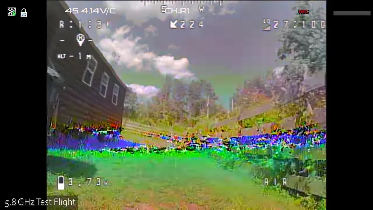 analogue DVR frame with breakup and colour distortion near a barn and fence line