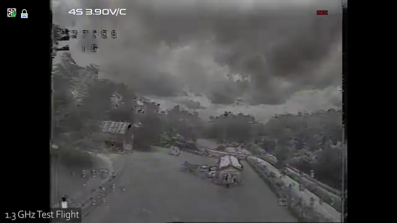 1.3 GHz DVR frame with severe breakup and distortion near a red barn and grassy field