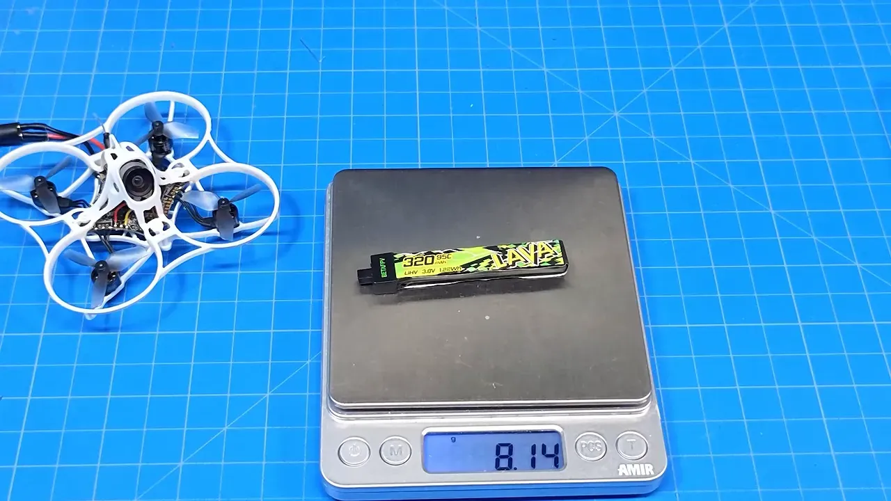 Small 1S batteries being weighed on a digital scale beside the Tinyhawk Aero
