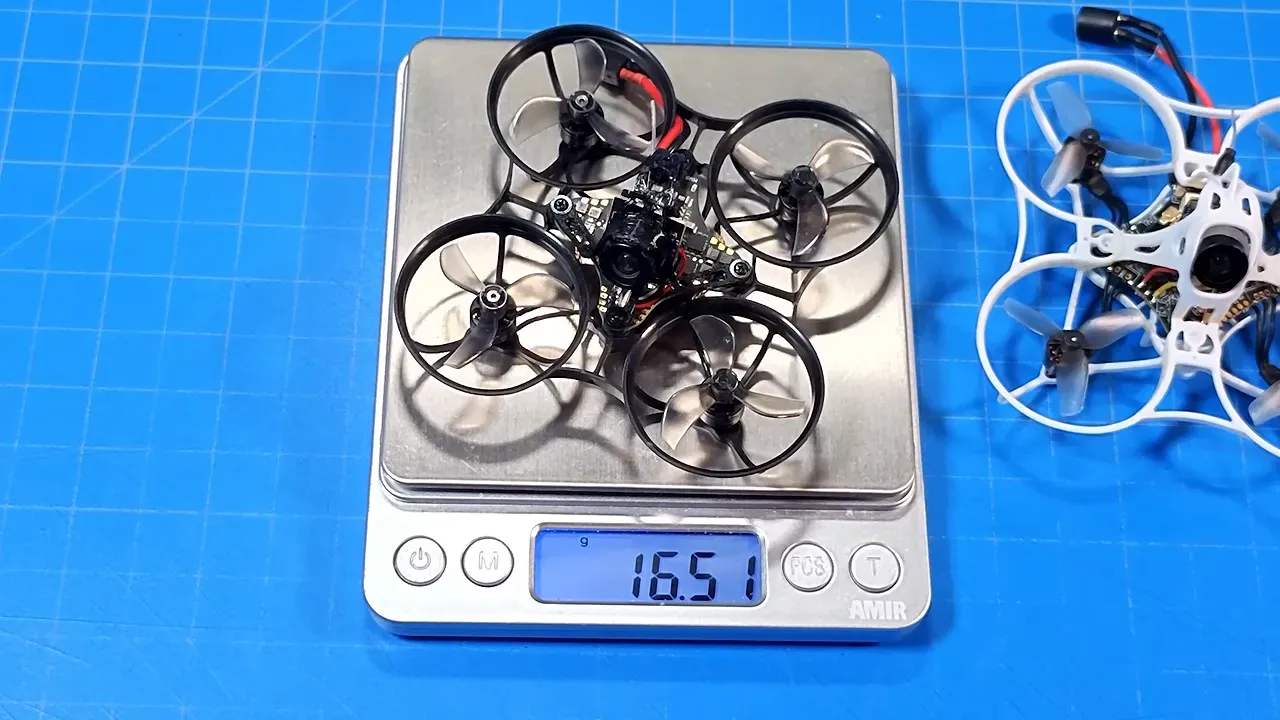 Several tiny whoops placed on digital scales beside the white Tinyhawk Aero
