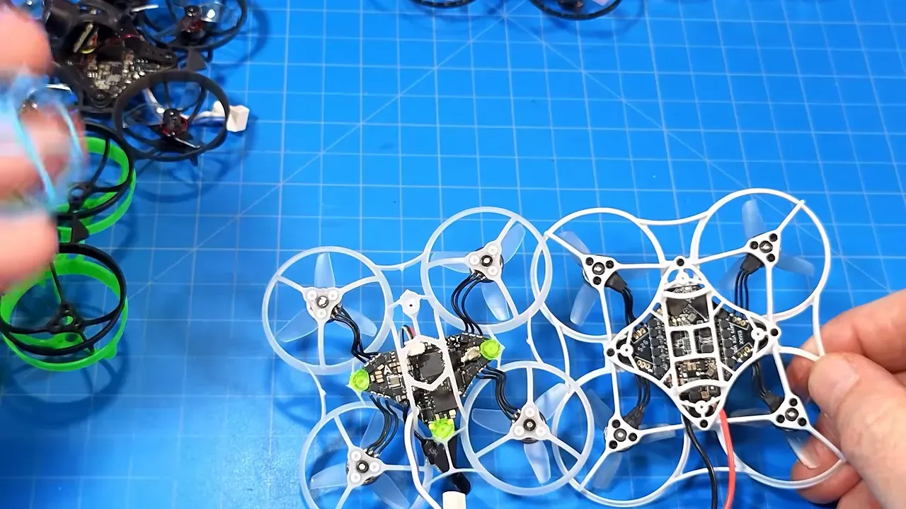 White Tinyhawk Aero placed among several whoop frames on a blue cutting mat
