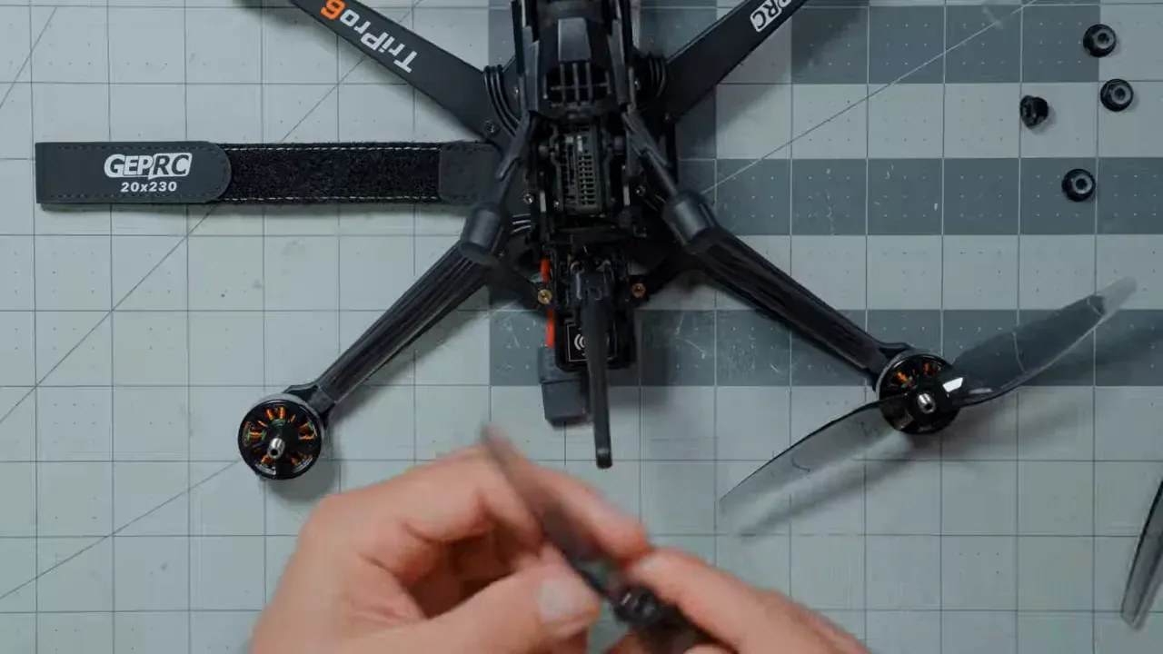 Top-down view of hands fitting propellers to the pusher motor layout