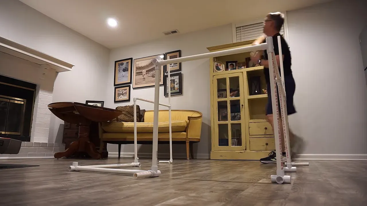 White PVC gate frames standing in a furnished room with a person behind them
