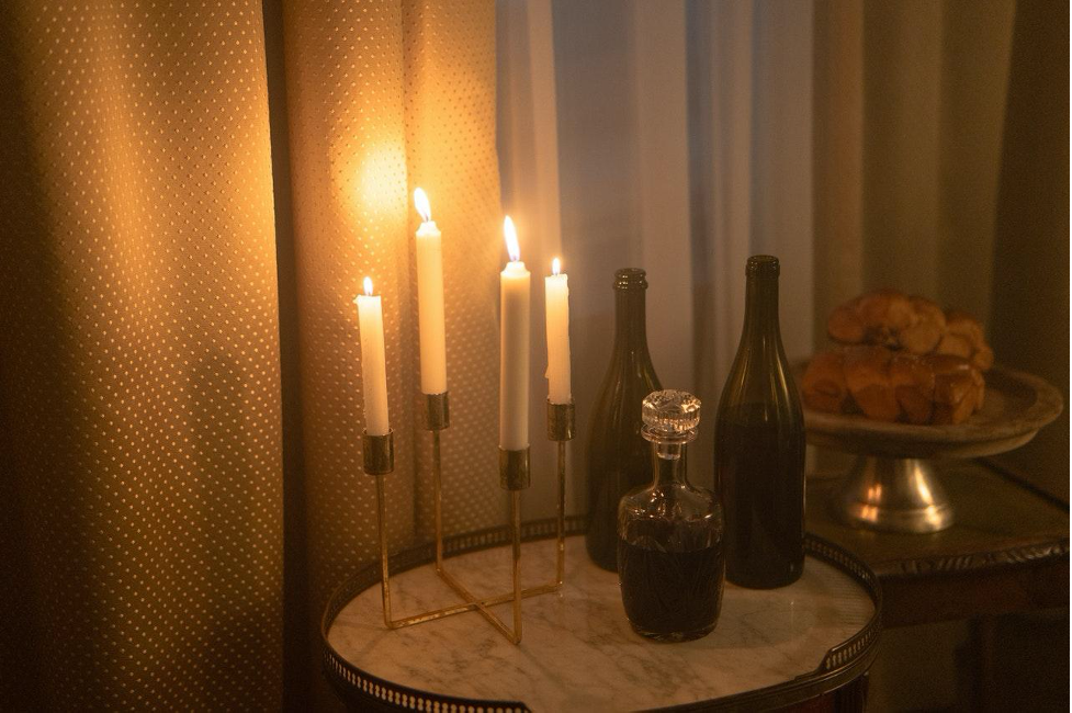 A table with wine and lit candles.