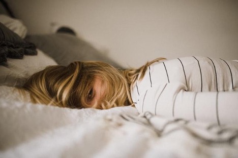 A woman laying face down in bed. 